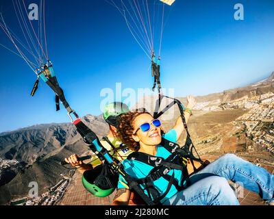 Happy Tourist tun Paragliding Sport Aktivität in der Freizeit aktiven Lebensstil. Fröhliche Erwachsene Frau macht Selfie-Bild fliegen auf einem Paraglyde in Stockfoto