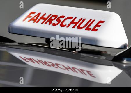 30. März 2022, Niedersachsen, Göttingen: Ein Dachschild mit der Aufschrift „Fahrschule“ ist an einem fahrenden Schulwagen angebracht. Foto: Swen Pförtner/dpa Stockfoto