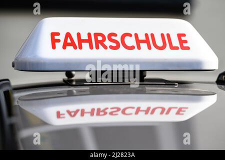 30. März 2022, Niedersachsen, Göttingen: Ein Dachschild mit der Aufschrift „Fahrschule“ ist an einem fahrenden Schulwagen angebracht. Foto: Swen Pförtner/dpa Stockfoto