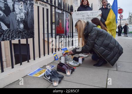 London, Großbritannien. 30.. März 2022. Demonstranten versammelten sich vor der Botschaft von Ungarn, um gegen die neutrale Haltung des Premierministers Viktor Orban gegenüber dem Krieg in der Ukraine und die Weigerung, die Ukraine zu unterstützen, zu protestieren. Demonstranten ließen Schuhe und zündeten Kerzen vor der Botschaft an, um an die von russischen Truppen Getöteten zu erinnern. Kredit: Vuk Valcic/Alamy Live Nachrichten Stockfoto