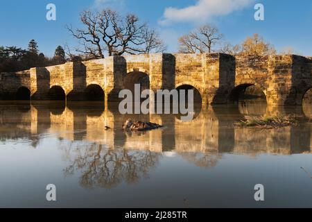 Ein später Winternachmittag an der Stopham Bridge über den Fluss Arun, einem denkmalgeschützten Bauwerk, das 1422-23 in der Nähe von Pulborough, West Sussex, Großbritannien, erbaut wurde Stockfoto