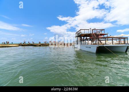 TAMANDARE, PE, Brasilien - 18. Oktober 2021: Touristen, die vom Katamaran in den natürlichen Pools des Carneiro-Strandes, an den Riffen, aussteigen. Stockfoto