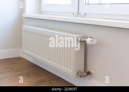 Wandmontierter Heizkörper mit Thermostat. Batterie. Stockfoto