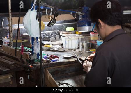 Thailändischer Juwelier, der in einer Werkstatt feinen Schmuck herstellt Stockfoto