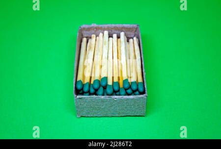 Holzmatches in Pappkarton auf grünem Hintergrund Stockfoto