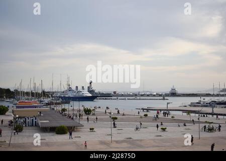 Blick auf Marina Flisvos im Palaio Faliro, Athen (hinter dem Kulturzentrum der Stavros Niarchos Foundation). Marina mit Booten und Menschen Stockfoto