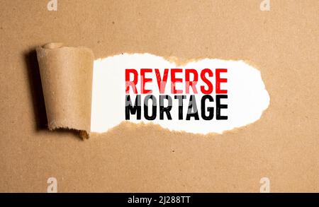 Textschild mit Reverse Mortgages. Konzeptionelle Foto-Entleiher, um den unbelasteten Wert der Immobilie zugreifen Wecker und zerrissene Pappe platziert Stockfoto