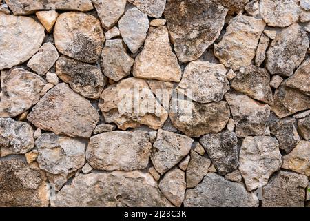 Hintergrund aus Kalkstein Mauerwerk. Die Oberfläche ist mit Naturmaterial verziert. Die Mauer ist aus Wildstein Stockfoto