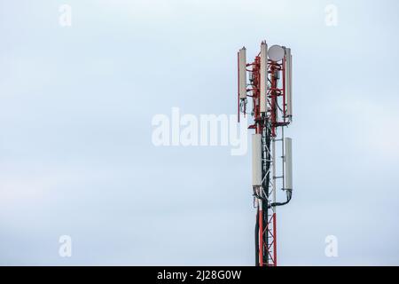Handy und Internetzelle ragen über den Himmel. 5G Funkstrahlantennen. Stockfoto