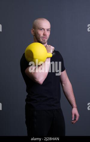 Kerl mit einem gelben Kettlebell Turnhalle anonymen gelben Mann, am Nachmittag Motivation Anstrengung für gemalt für bis Gewichtheben, asiatische Fitness. Gesund Stockfoto