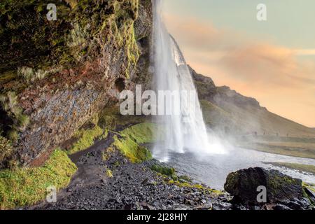 Der ikonische Seljalandsfoss Wasserfall und der dahinter liegende Wanderweg, Südisland Stockfoto