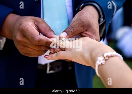 Bräutigam legt Ring auf den Finger der Braut Nahaufnahme der Hände und Ring Stockfoto