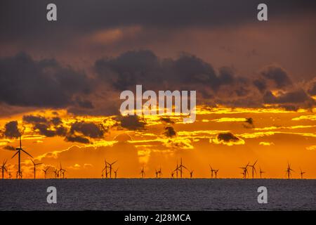 Walney Island, Cumbrian Coast. 30.. März 2022. Wetter in Großbritannien. Nach einem Tag mit Regen, grauem Himmel und einer kalten Nordbrise. Sonnenuntergang von der Cumbrian Coast, Blick über die Irische See zur entfernten Walney Offshore Windfarm. Kredit:greenburn/Alamy Live Nachrichten. Stockfoto