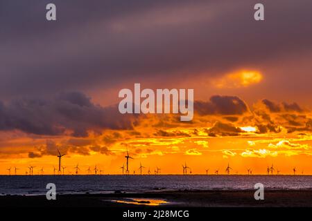 Walney Island, Cumbrian Coast. 30.. März 2022. Wetter in Großbritannien. Nach einem Tag mit Regen, grauem Himmel und einer kalten Nordbrise. Sonnenuntergang von der Cumbrian Coast, Blick über die Irische See zur entfernten Walney Offshore Windfarm. Kredit:greenburn/Alamy Live Nachrichten. Stockfoto