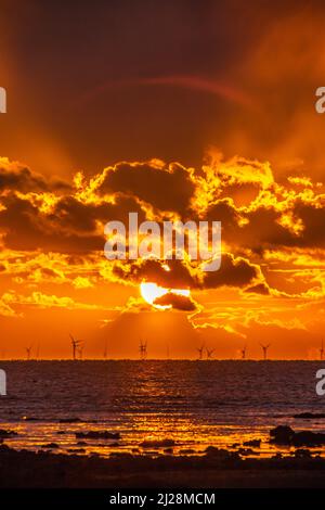 Walney Island, Cumbrian Coast. 30.. März 2022. Wetter in Großbritannien. Nach einem Tag mit Regen, grauem Himmel und einer kalten Nordbrise. Sonnenuntergang von der Cumbrian Coast, Blick über die Irische See zur entfernten Walney Offshore Windfarm. Kredit:greenburn/Alamy Live Nachrichten. Stockfoto