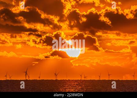 Walney Island, Cumbrian Coast. 30.. März 2022. Wetter in Großbritannien. Nach einem Tag mit Regen, grauem Himmel und einer kalten Nordbrise. Sonnenuntergang von der Cumbrian Coast, Blick über die Irische See zur entfernten Walney Offshore Windfarm. Kredit:greenburn/Alamy Live Nachrichten. Stockfoto