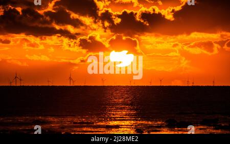 Walney Island, Cumbrian Coast. 30.. März 2022. Wetter in Großbritannien. Nach einem Tag mit Regen, grauem Himmel und einer kalten Nordbrise. Sonnenuntergang von der Cumbrian Coast, Blick über die Irische See zur entfernten Walney Offshore Windfarm. Kredit:greenburn/Alamy Live Nachrichten. Stockfoto