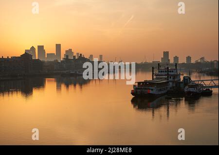 Goldener Sonnenaufgang über der Themse und mit Canary Wharf an der Skyline, London England Stockfoto