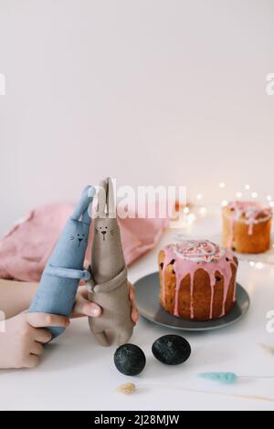 Osterkuchen, bunte Eier und Kaninchenspielzeug. Frohe Osterferien Konzept. Festliche Frühlingszeit Stockfoto