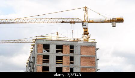 Baustelle, generische unfertige leere Wohngebäude und ein Kran, Wohnblock im Bau, neue moderne Immobilien-Wohnungen dev Stockfoto