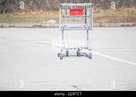 Ein alter rostiger verlassene Metalleinkaufswagen wurde draußen auf dem Parkplatz gelassen Stockfoto