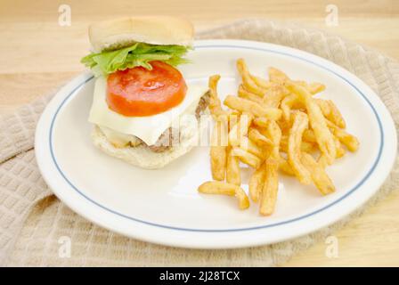 Knusprige Pommes in einem Teller mit einem Cheeseburger Stockfoto