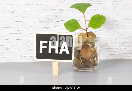 FHA-Symbol. Holzwürfel bilden das Wort "FHA, Bundeswohnungsverwaltung". Schöner grauer Hintergrund, Kopierbereich. Business- und FHA-Konzept. Stockfoto