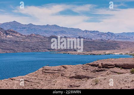 Nelson, Nevada, USA - 21. Mai 2011: Beide trockenen braunen Wüstenstränge des blauen Colorado River unter blauer Wolkenlandschaft. Berge auf der Arizona-Seite. Stockfoto