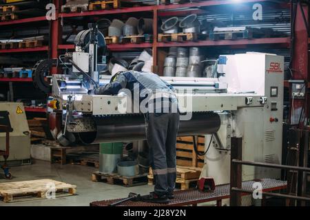 Arbeiter repariert Werkzeugmaschine. Stockfoto