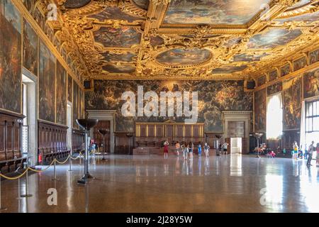 Venedig, Italien - 7. Juli 2021: Die Kammer des Großen rates im Dogenpalast mit Touristen. Deckendetails. Stockfoto