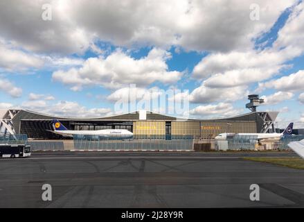 Frankfurt, Deutschland - 31. Juli 2021: lufthansa-Wartungshalle im Schmetterlingsbau mit Parkplatz der Boeing 747 und einem Airbus vor dem Flugzeug und vorbeifahrenden cr Stockfoto