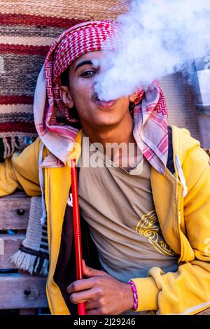 Ein Porträt eines jungen Mannes, der eine Shisha-Pfeife rauchen, Petra, Jordanien, Asien. Stockfoto