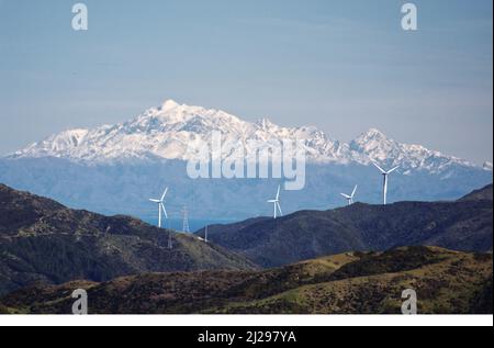 Mt Tapuae-o-Uenuku auf der Südinsel Neuseelands, mit Herbstschnee. Im Vordergrund Windturbinen am Boden der Nordinsel. Stockfoto