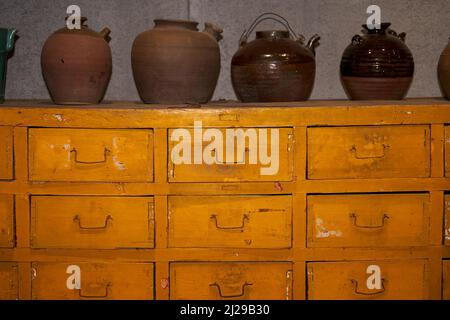 Kräutermedizinschrank und chinesischer Arzneitopf in einem chinesischen Kräutermedizingeschäft Stockfoto