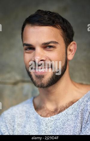 Gut aussehend ist der Mann, der glücklich ist. Aufnahme eines hübschen jungen Mannes, der im Freien posiert. Stockfoto