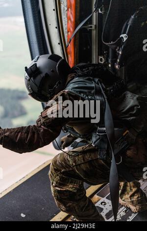 Ein 23d-flügiger HC-130 Combat King II Rescue Loadmaster führt an Bord eines HC-130J Combat King II, Moody Air Force Base, Georgia, 24. März 2022, ein Türbündel-Ausstiegsverfahren durch. Mitglieder der 820. BDG erweiterten ihre Fähigkeiten als Jumpmaster/Fallschirmspringer durch Ausführung von Türbündel und alternativen Türausstiegsverfahren (ADEPT) 2. (USA Luftwaffe Foto von 1. LT Katie Tamesis) Stockfoto