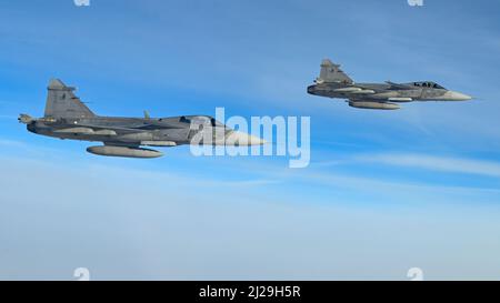 Zwei tschechische Luftstreitkräfte Saab JAS-39 Gripen fliegen in Formation zusammen mit einer B-52H-Stratofortress, die dem Expeditionary Bomb Squadron 69. bei RAF Fairford, England, im Rahmen der vorgeplanten Bomber Task Force Europe-Missionsreihe, 29. März 2022, zugewiesen wurde. B-52s von der 69. EBS flog in die Tschechische Republik, um sich mit US-Alliierten zu integrieren, um die Interoperabilität zwischen Jagdbombern und Bombern zu stärken. (USA Luftwaffe Foto von Airman 1. Klasse Zachary Wright) Stockfoto