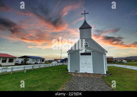 Graue Holzkirche und Wohnungen im Dorf, Abendhimmel, Bakkagerdi, Bakkageroi, Borgarfjordur eystri, Austurland, Island Stockfoto