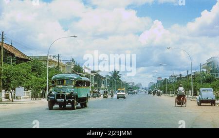 Weite, leere Straßen von Phnom Penh, der kambodschanischen Hauptstadt, im Jahr 1966, erinnert der ganz rechts stehende City2CV an die kolonialen Ursprünge der Stadt Stockfoto
