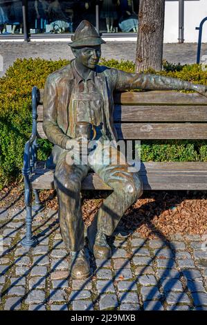 Bronzefigur, bayerisch mit Bierkrug auf Holzbank, Immenstadt, Allgäu, Bayern, Deutschland Stockfoto