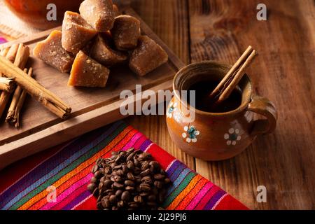 Cafe de Olla. Traditioneller mexikanischer Kaffee und Grundzutaten für seine Zubereitung, Kaffee, Zimt und Piloncillo, serviert in einer Tonbecher namens 'Jarr Stockfoto