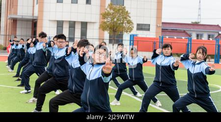 HAI'AN, CHINA - 31. MÄRZ 2022 - das Foto vom 31. März 2022 zeigt Studenten, die auf dem Spielplatz der Huji Junior High School in Kampfkunst üben Stockfoto
