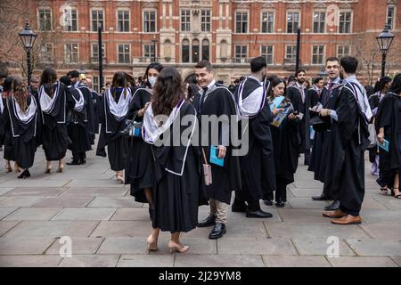 Absolventen des Imperial College London genießen die Atmosphäre außerhalb der Royal Albert Hall, obwohl Eltern oder Familienmitglieder nicht teilnehmen durften. Stockfoto