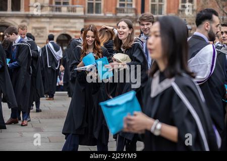 Absolventen des Imperial College London genießen die Atmosphäre außerhalb der Royal Albert Hall, obwohl Eltern oder Familienmitglieder nicht teilnehmen durften. Stockfoto