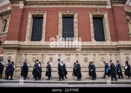 Absolventen des Imperial College London genießen die Atmosphäre außerhalb der Royal Albert Hall, obwohl Eltern oder Familienmitglieder nicht teilnehmen durften. Stockfoto