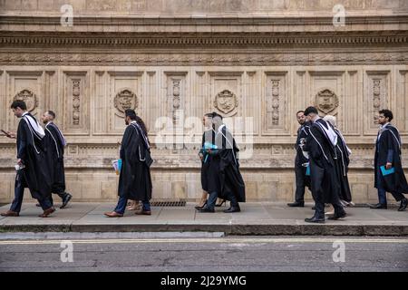 Absolventen des Imperial College London genießen die Atmosphäre außerhalb der Royal Albert Hall, obwohl Eltern oder Familienmitglieder nicht teilnehmen durften. Stockfoto