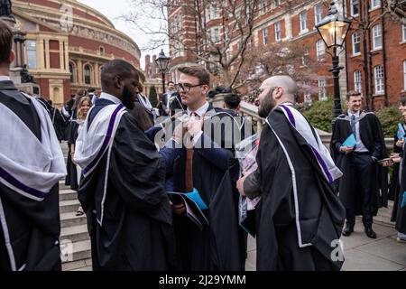 Absolventen des Imperial College London genießen die Atmosphäre außerhalb der Royal Albert Hall, obwohl Eltern oder Familienmitglieder nicht teilnehmen durften. Stockfoto