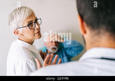 Der Arzt bespricht die Diagnose mit dem besorgten älteren Patienten. Gesundheitskonzept Stockfoto