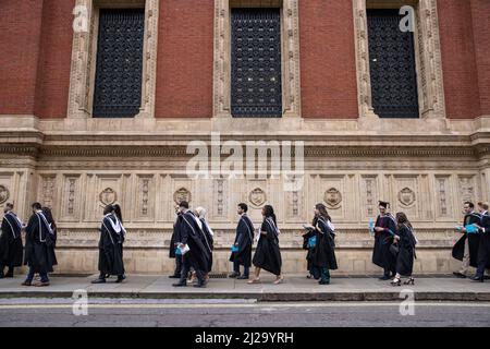 Absolventen des Imperial College London genießen die Atmosphäre außerhalb der Royal Albert Hall, obwohl Eltern oder Familienmitglieder nicht teilnehmen durften. Stockfoto