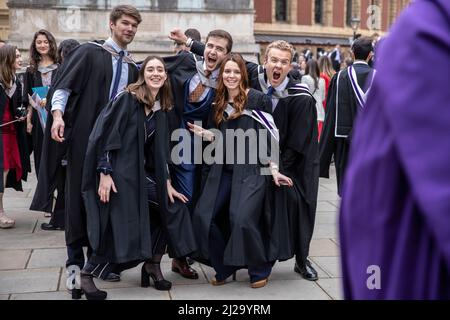 Absolventen des Imperial College London genießen die Atmosphäre außerhalb der Royal Albert Hall, obwohl Eltern oder Familienmitglieder nicht teilnehmen durften. Stockfoto